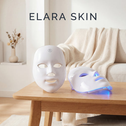 Two LED face masks on a wooden table with 'ELARA SKIN' branding.